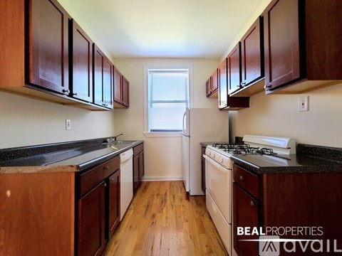 A kitchen with wooden cabinets and a white refrigerator.
