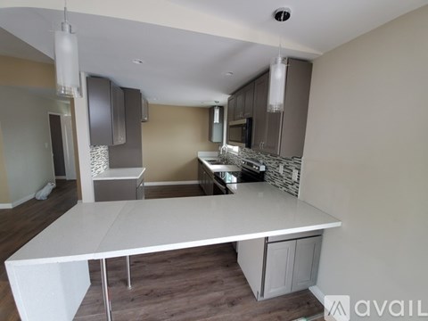 A kitchen with a white table and cabinets.