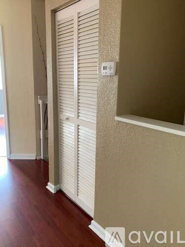 A room with a closed white shutter and a wall socket.