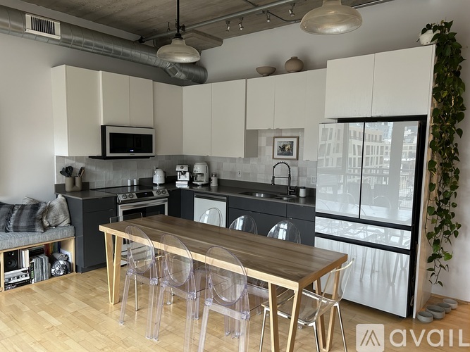 A modern kitchen with a wooden table and chairs.