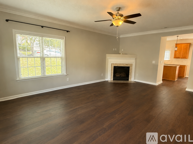 A spacious living room with a fireplace and hardwood floors.