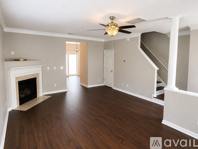 A spacious room with a fireplace and wooden flooring.