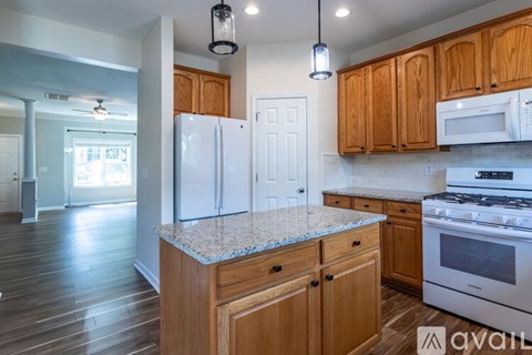 A kitchen with wooden cabinets and a granite countertop.