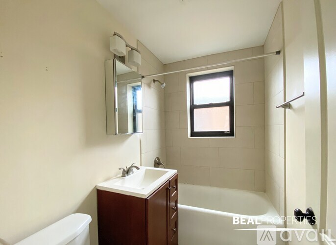 A bathroom with a white tub, sink, and mirror.