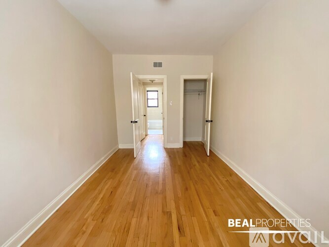 A hallway with wooden floors and two doors.