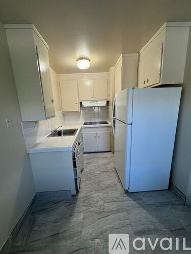 A kitchen with white appliances and cabinets.