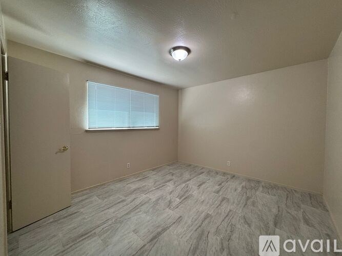 A room with a window and a door is available for rent.