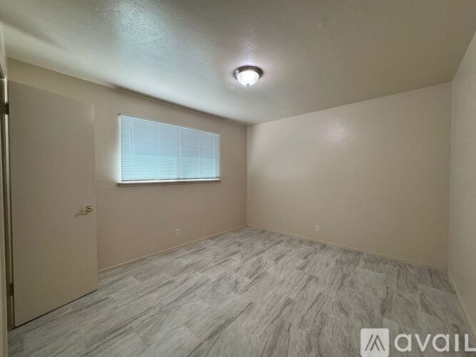 A room with a window and a door is available for rent.