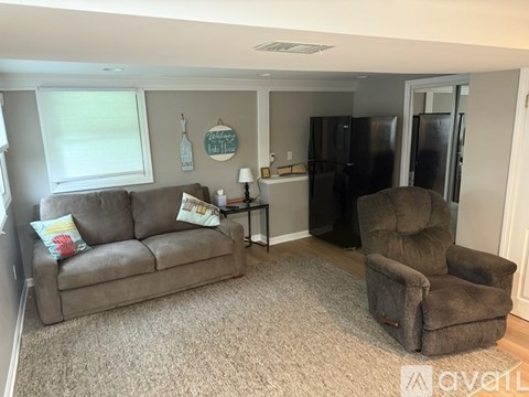 A living room with a grey couch and a brown recliner.
