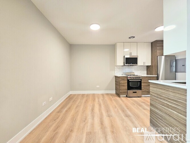 A kitchen with white cabinets and a wooden floor.