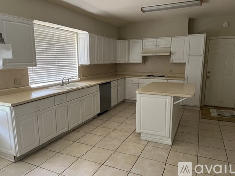 A kitchen with white cabinets and a countertop.