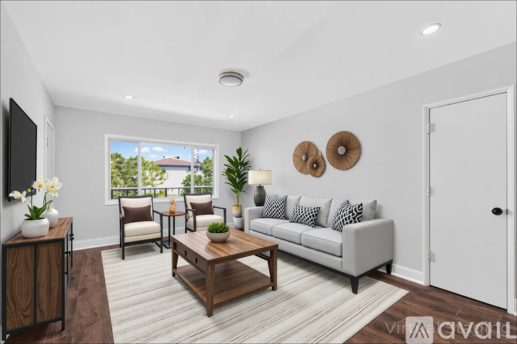 A room with white cabinets and drawers and a wooden floor.
