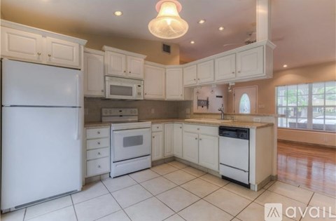 A kitchen with white appliances and cabinets.