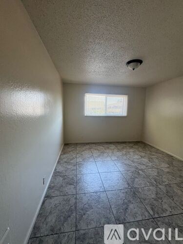 A room with a tiled floor and a window letting in light.