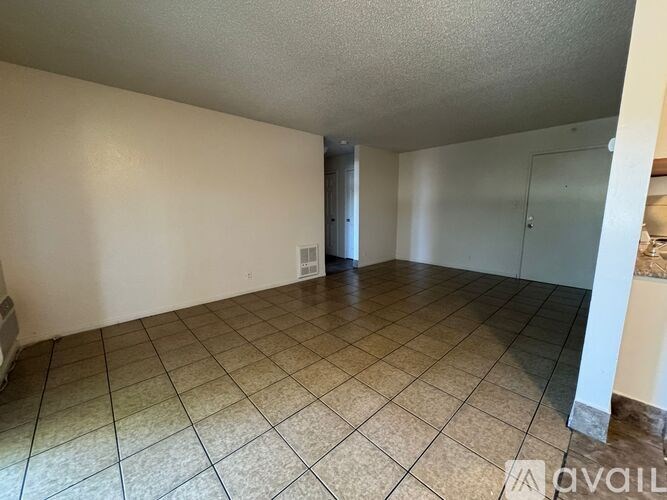 Empty room with tiled floor and white walls.