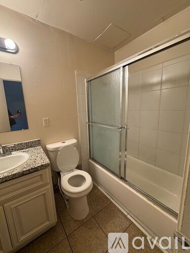 A bathroom with a toilet, sink, and shower.