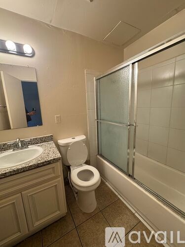 A bathroom with a toilet, sink, and shower.