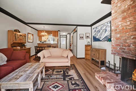 A living room with a fireplace and a rug on the floor.
