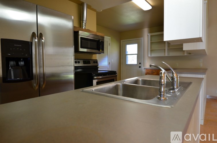 A kitchen with a stainless steel refrigerator, microwave, and oven.