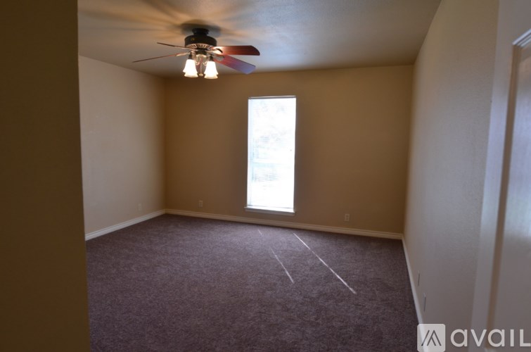 A room with a ceiling fan and a window.