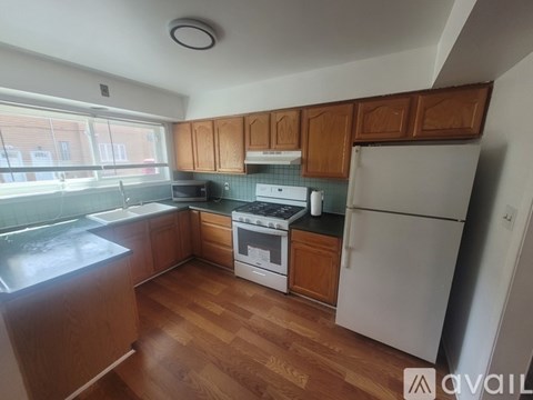 A kitchen with wooden cabinets and a white fridge.