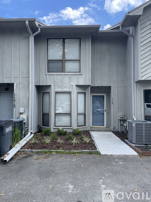 A grey house with a white door and windows.