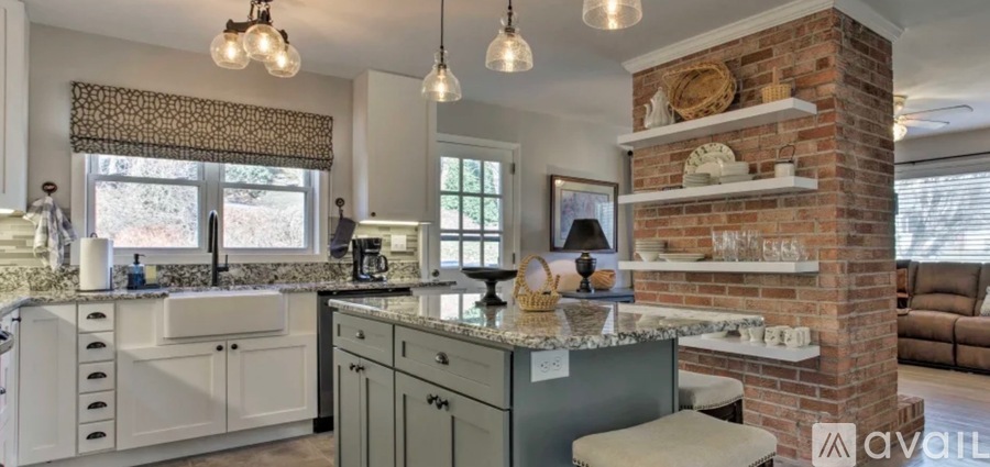 A kitchen with a brick column and a countertop with a sink.