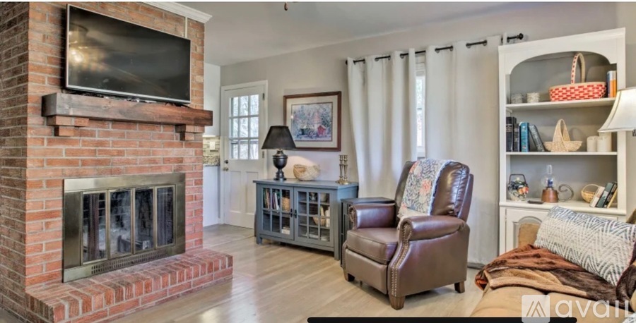 A living room with a fireplace and a television above it.