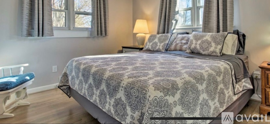 A bedroom with a large bed and a blue chair.
