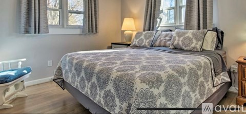 A bedroom with a large bed and a blue chair.