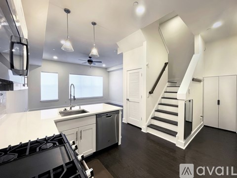 A modern kitchen with white cabinets and a black stove top.