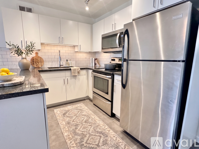 A kitchen with a refrigerator, microwave, and oven.