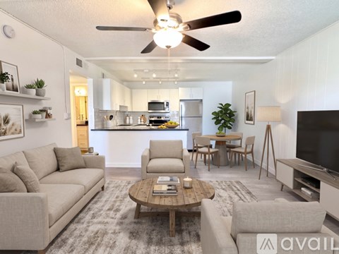 A kitchen with white cabinets and black countertops.