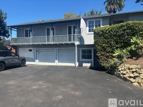 A two-story house with a garage and a car parked in front.
