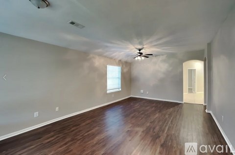 A room with wooden flooring and a ceiling fan.