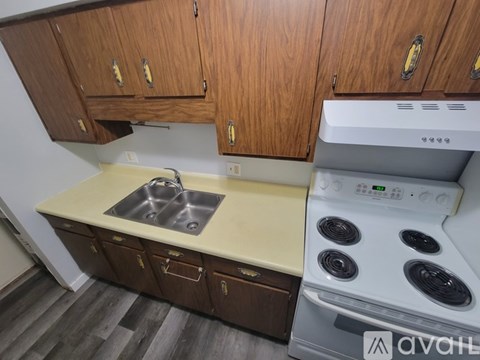 A kitchen with wooden cabinets and a white stove top oven.