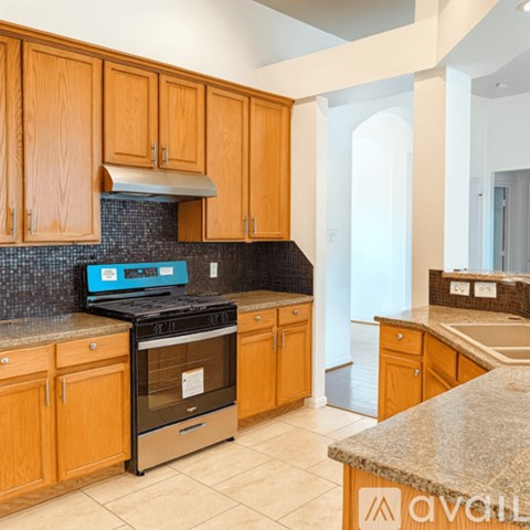 A kitchen with wooden cabinets and a black stove top oven.