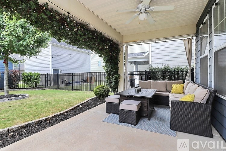 A patio with a table and chairs under a roof.