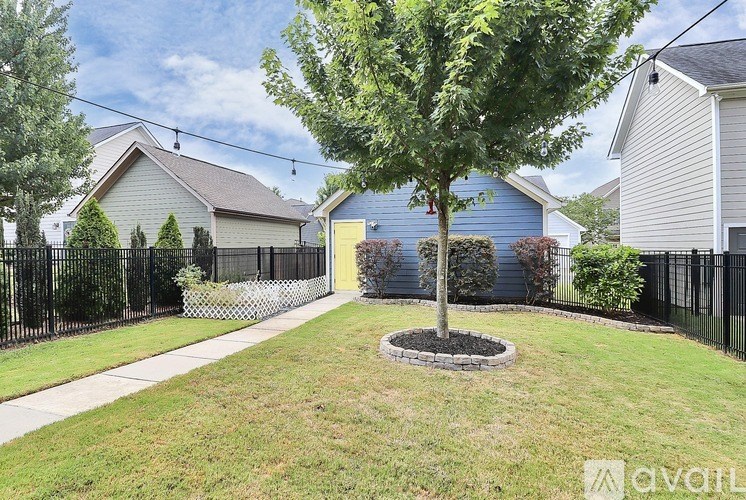 A tree in a circle of stones is the centerpiece of a well-kept yard.
