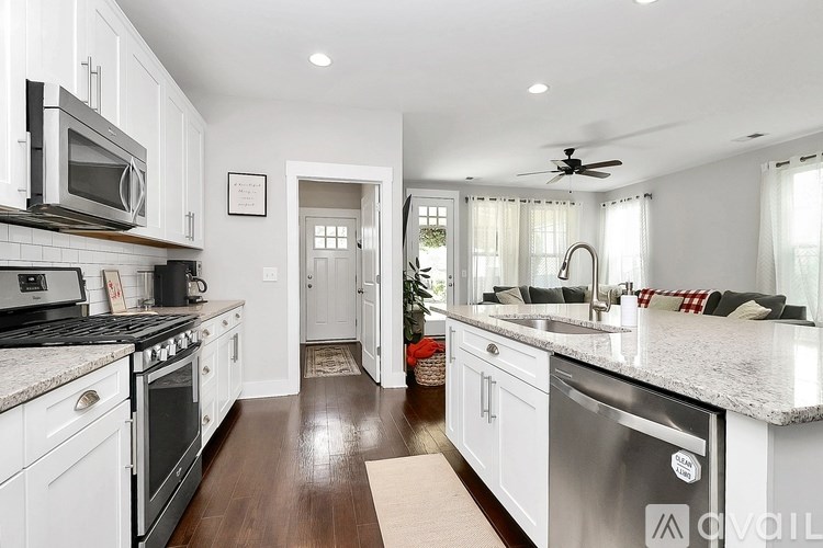 A kitchen with white cabinets and a stainless steel dishwasher.