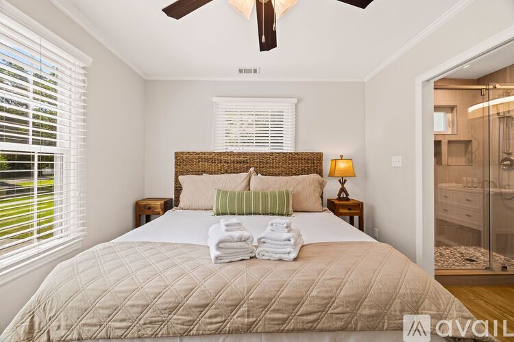 A bedroom with a large bed and a ceiling fan.