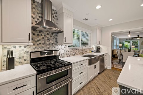 A kitchen with a stove top oven and a hood.