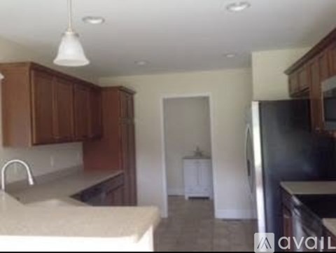 A kitchen with wooden cabinets and a black refrigerator.