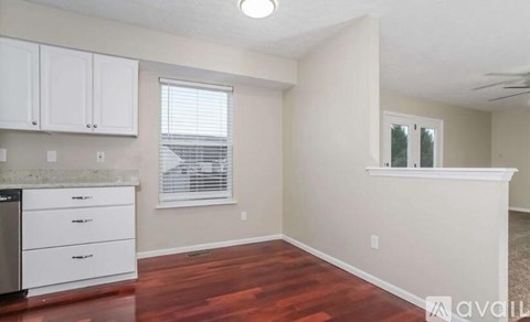 A kitchen area with white cabinets and a countertop.