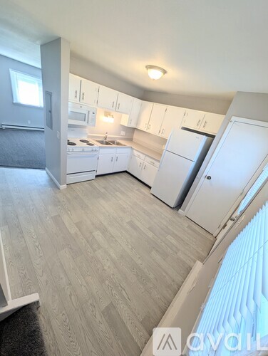 A kitchen with white appliances and cabinets.