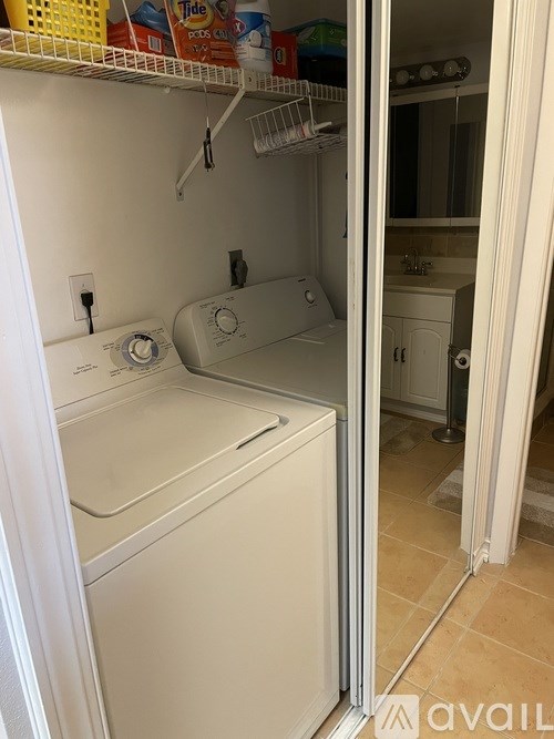 A white dryer is in a small laundry room.
