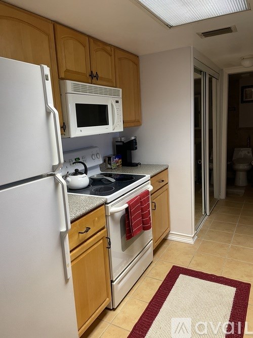 A kitchen with wooden cabinets and a white refrigerator.