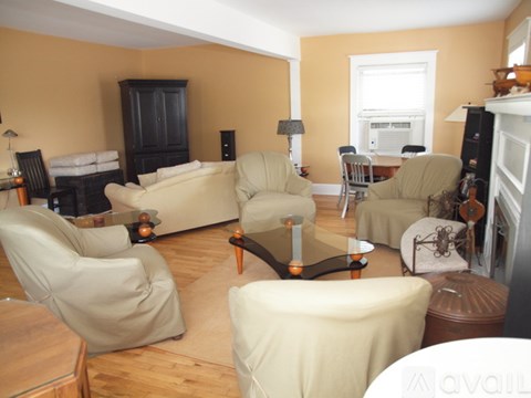 A living room with a white couch and a glass coffee table.