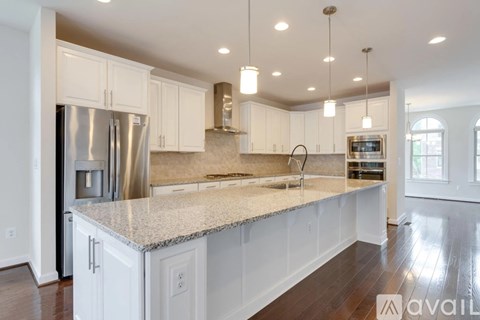 A kitchen with white cabinets and a granite countertop.