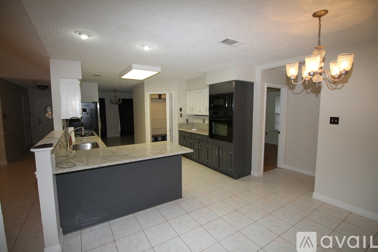 A kitchen with a marble countertop and a chandelier.